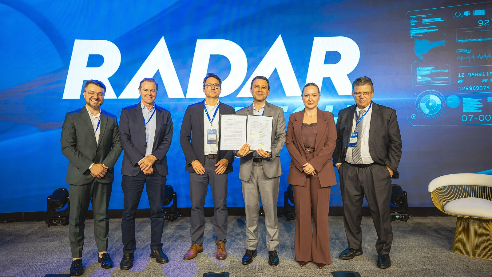Representantes da FIESC e da AWS com termo de cooperação no palco do RADAR Tech