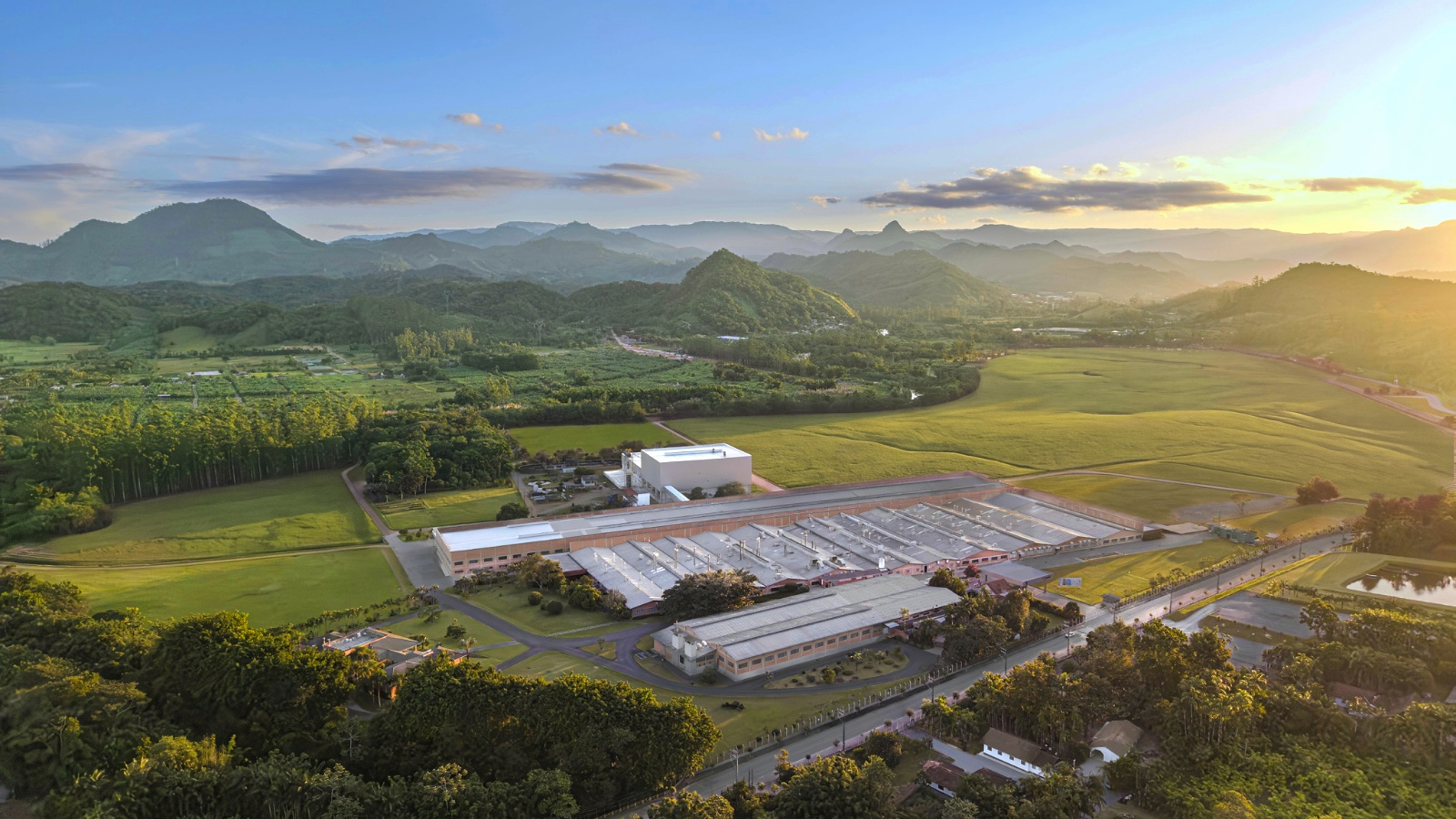 Vista aérea de instalação industrial da Lunelli entre áreas verdes e montanhas